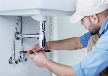plumber fixing sink plumbing in California home